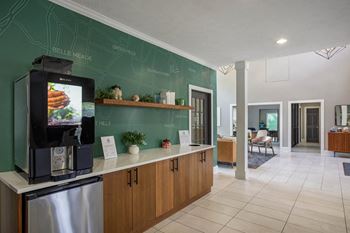 A kitchen with a coffee machine and a green wall